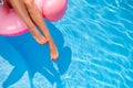 Slim woman legs relaxing on inflatable pink flamingo float mattress at swimming pool. Attractive fit girl lower body Royalty Free Stock Photo