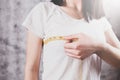 Slim woman measures her breast with a measuring tape Royalty Free Stock Photo