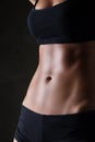 Slim woman's body over dark gray background