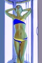 Slim woman in solarium getting sun tan Royalty Free Stock Photo