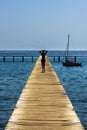 Slim woman walking along a jetty