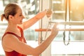 Slim woman wearing sports attire having anaerobic exercise on reformer