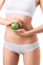 Slim woman in white underwear with green apple at