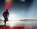 Slim young fitness man runner on beach, tropical trail runner. Cheerful sportsman run on beach