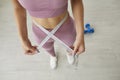 Slim girl who& x27;s been doing weight loss workouts shows tape measure on her thin waist Royalty Free Stock Photo