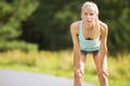 Slim young woman catching her breath after a long run Royalty Free Stock Photo