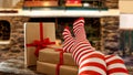 Slim Young Woman Legs With Red And White Christmas Stockings. Fireplace Background.