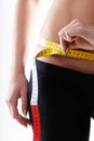 Slim young woman measuring her hips with a tape measure Royalty Free Stock Photo