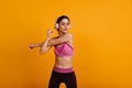 Slim young woman in pink tank-top doing cardio. Sporty girl in headphones having fun Royalty Free Stock Photo