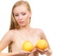 Woman small boobs holds big orange fruits