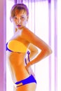 Slim young woman standing in solarium getting sun tan Royalty Free Stock Photo