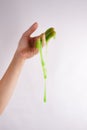 Slime paste green elastic and viscous, woman hand holding slime