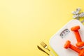 Slimming concept. Top view photo of red dumbbells cutlery tape measure and scales on isolated pastel yellow background with empty Royalty Free Stock Photo