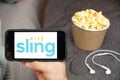 Sling logo on the smartphone screen with popcorn box and Apple earpods on the background, September 2020, San Francisco