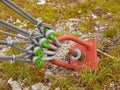 Sling and scrap in green yard, iron twisted rope fixed by screws snap hooks and grommets at anchor in ground. Royalty Free Stock Photo