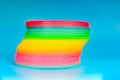 Slinky, plastic toy with colors of the rainbow, colorful children`s spring on a blue background Royalty Free Stock Photo