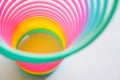 Slinky, plastic toy with colors of the rainbow, colorful children`s spring on a blue background.