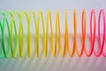 Slinky, plastic toy with colors of the rainbow, colorful children`s spring on a blue background.