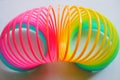 Slinky, plastic toy with colors of the rainbow, colorful children`s spring on a blue background.