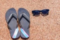 Slip slops sunscreen and sunglasses on a beach Royalty Free Stock Photo