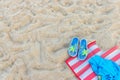 Slippers with colorful starfish and mat on sand on a beach Royalty Free Stock Photo