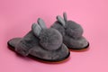 Slippers with fluffy ears, comfortable women`s home shoes on a pink background