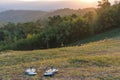 Slippers placed on green lawn with background mountains at sunset Royalty Free Stock Photo