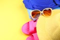 Slippers, swimsuit bikini, towel, hat and sunglasses on a pastel yellow background. Travel, sea, vacation, holiday. Royalty Free Stock Photo