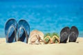 A Slippers of the whole family in the sand by the sea on nature while traveling. Rest by the water on vacation with shoes Royalty Free Stock Photo