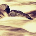 Slippery boulders in mountain stream. Clear water blurred by long exposure, low water level. Royalty Free Stock Photo