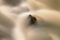 Slippery boulders in mountain stream. Clear water blurred by long exposure, reflection in water level. Soft focus. Royalty Free Stock Photo