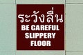 Slippery Floor Sign - In Thai & English Language Royalty Free Stock Photo