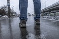 Slippery road covered ice. Man`s foots on frozen winter way after freezing rain Royalty Free Stock Photo