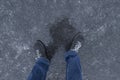 Slippery road covered ice. Man`s foots on frozen winter way after freezing rain Royalty Free Stock Photo