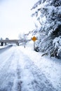 Slippery snow covered road and forest in December with stop ahead sign, vertical Royalty Free Stock Photo