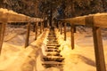 Slippery wooden staircase in pine tree forest fully covered in snow. Winter wonderland. Stairs going up. Lappland, Northern Sweden