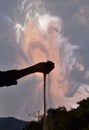 Slipping off sand from black shaded hand and arm with magical sky and mountains background at Jammu city, Jammu and Kashmir, India