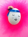 Slipping and smiling face painted on egg on pink background Royalty Free Stock Photo