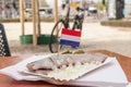 Slised herring with flag of Netherlands. Onion and cucumber. Bicycle on the background