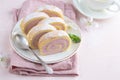 Slised strawberry swiss roll cake on white plate