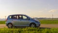 Sliven, Bulgaria- September 6 ,2021: Blue car Honda Jazz parked on the road against the background of green fields and sunny sky. Royalty Free Stock Photo