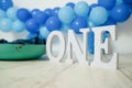 sliver, blue and white decoration for a 1st birthday cake smash studio photo shoot with balloons, paper decor, cake and Royalty Free Stock Photo