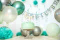 sliver, blue and white decoration for a 1st birthday cake smash studio photo shoot with balloons, paper decor, cake and Royalty Free Stock Photo