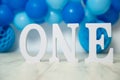 sliver, blue and white decoration for a 1st birthday cake smash studio photo shoot with balloons, paper decor, cake and Royalty Free Stock Photo