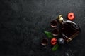 Slivovica - plum vodka, plum brandy in a bottle on a black stone table. Glasses with alcoholic beverage. Royalty Free Stock Photo