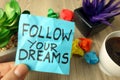 Slogan follow your dreams handwritten on sticky note Royalty Free Stock Photo