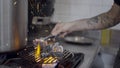 Slomo of sparks flying as chef moves charcoal on grill grate on stove