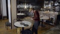 Slomo of young woman moving plates from round restaurant table