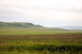 The slope of a high mountain at the beginning of the endless steppe flooded with sunlight