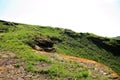 The slope of a high mountain with the remains of ancient buildings overgrown with green grass